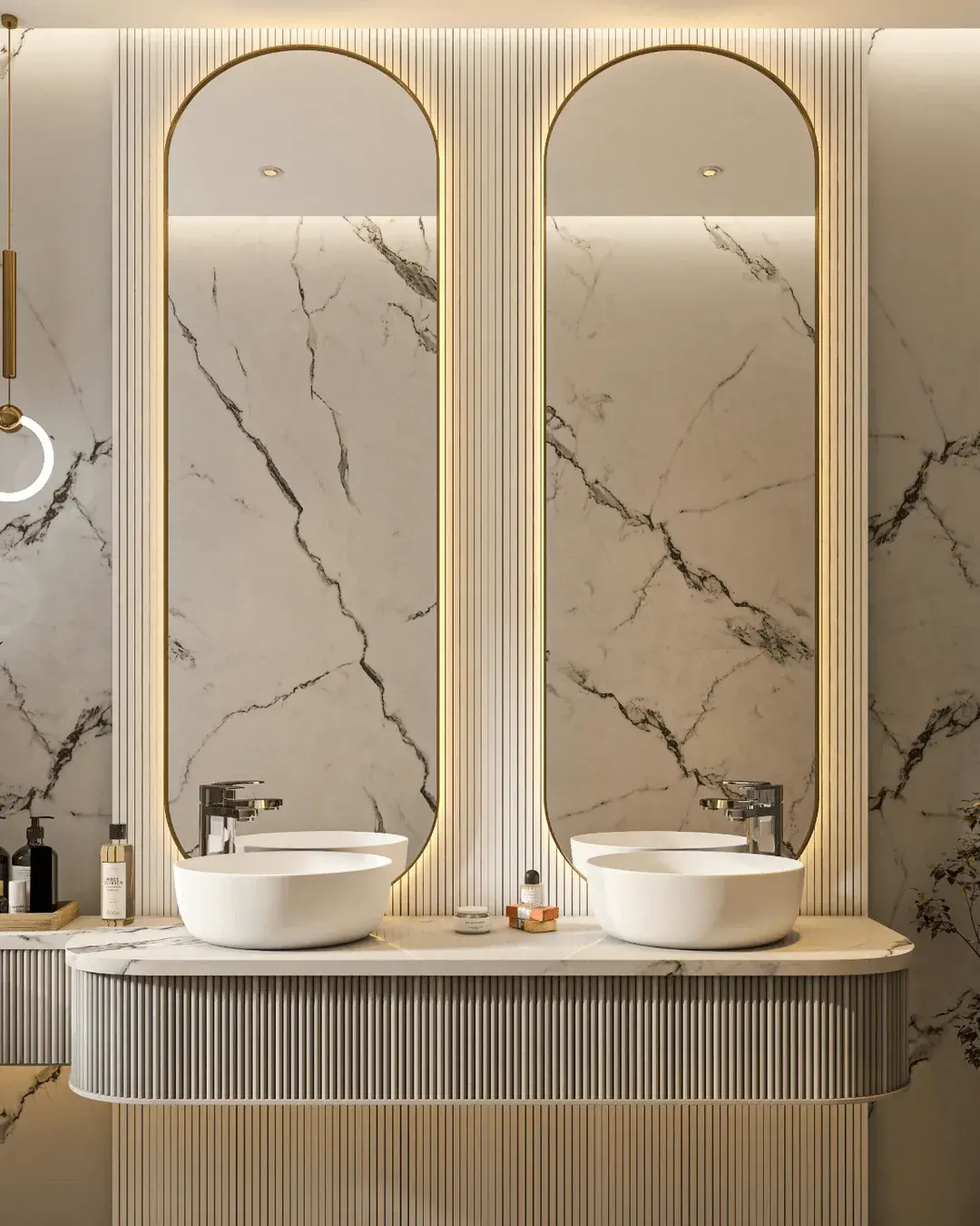 A marble bathroom with brass arch mirrors and twin basins